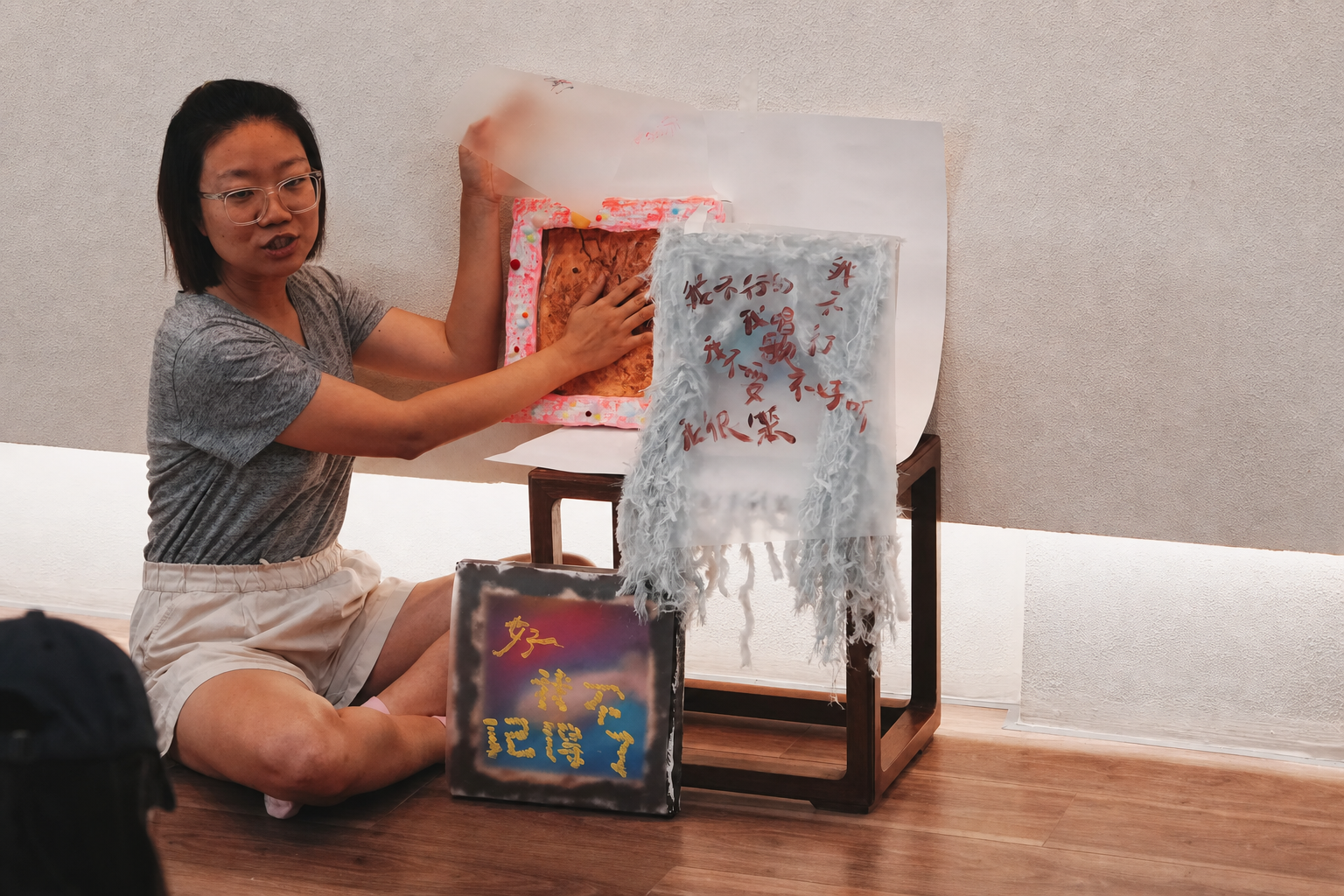 A participant presenting a series of reflective mixed-media works