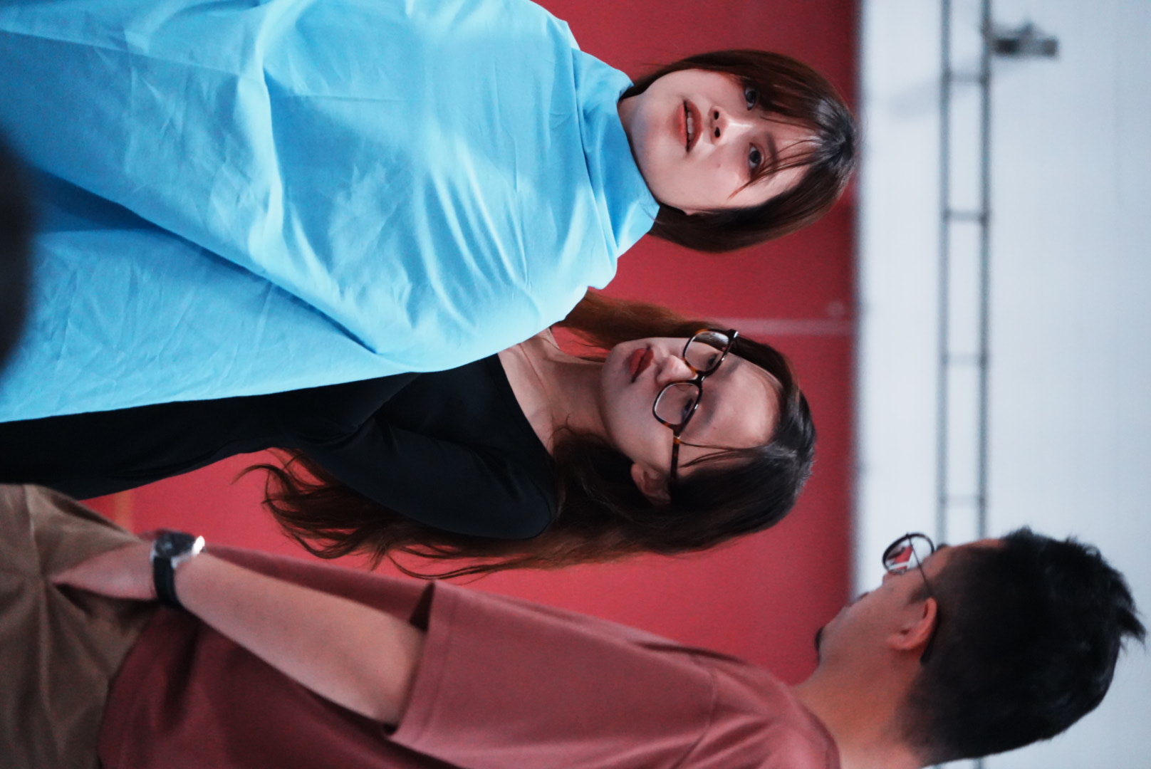 A supported embodied exercise using blue fabric in a theatre workshop